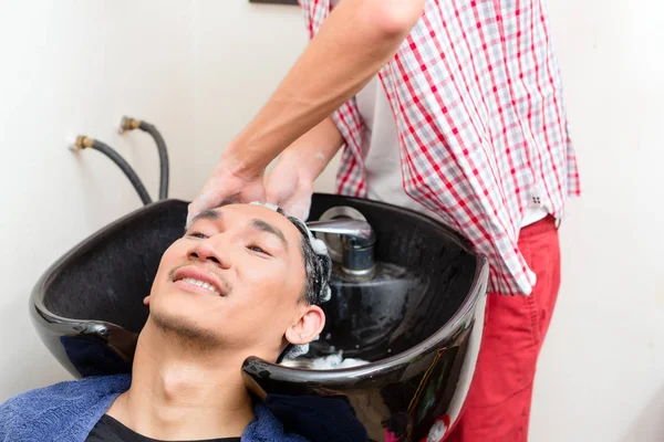 Barbiere che lava capelli in lavandino — Foto Stock