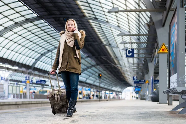 Mujer con su equipaje caminando por la plataforma en la estación de tren — Foto de Stock