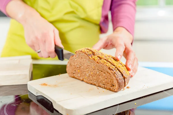 Mujer cortando pan para sándwich — Foto de Stock