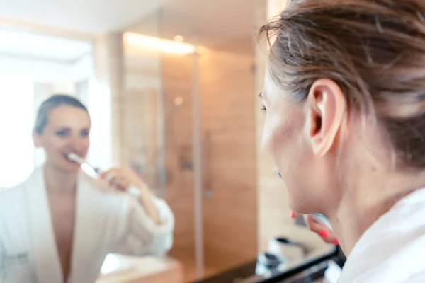 Mujer cepillándose los dientes en lujoso hotel —  Fotos de Stock