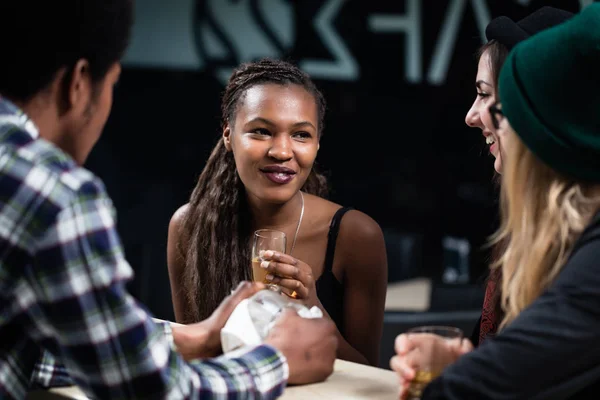 Усміхнена дівчина насолоджується напоями зі своїми друзями — стокове фото