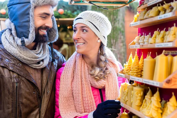 Pareja en el mercado de Navidad comprando velas como regalo — Foto de Stock