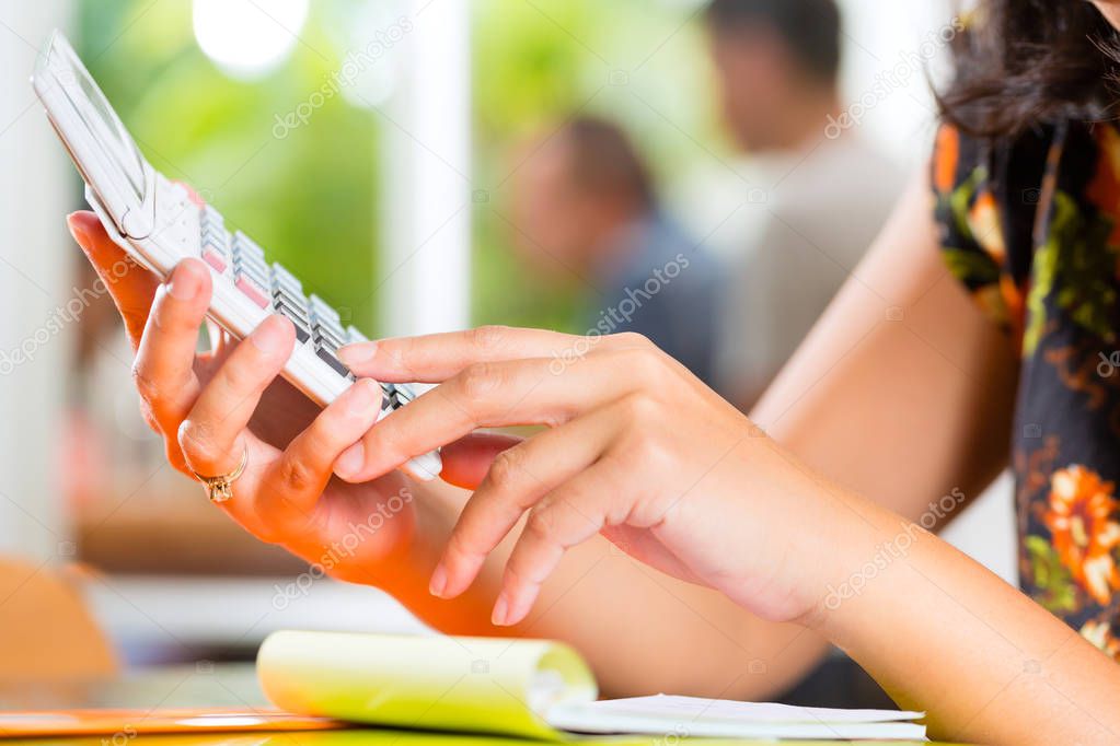 Close-up of hands holding calculator