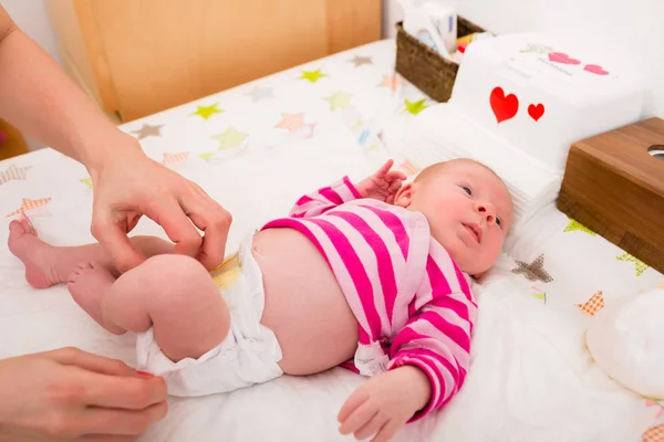 Woman changing the babys diaper — Stock Photo, Image