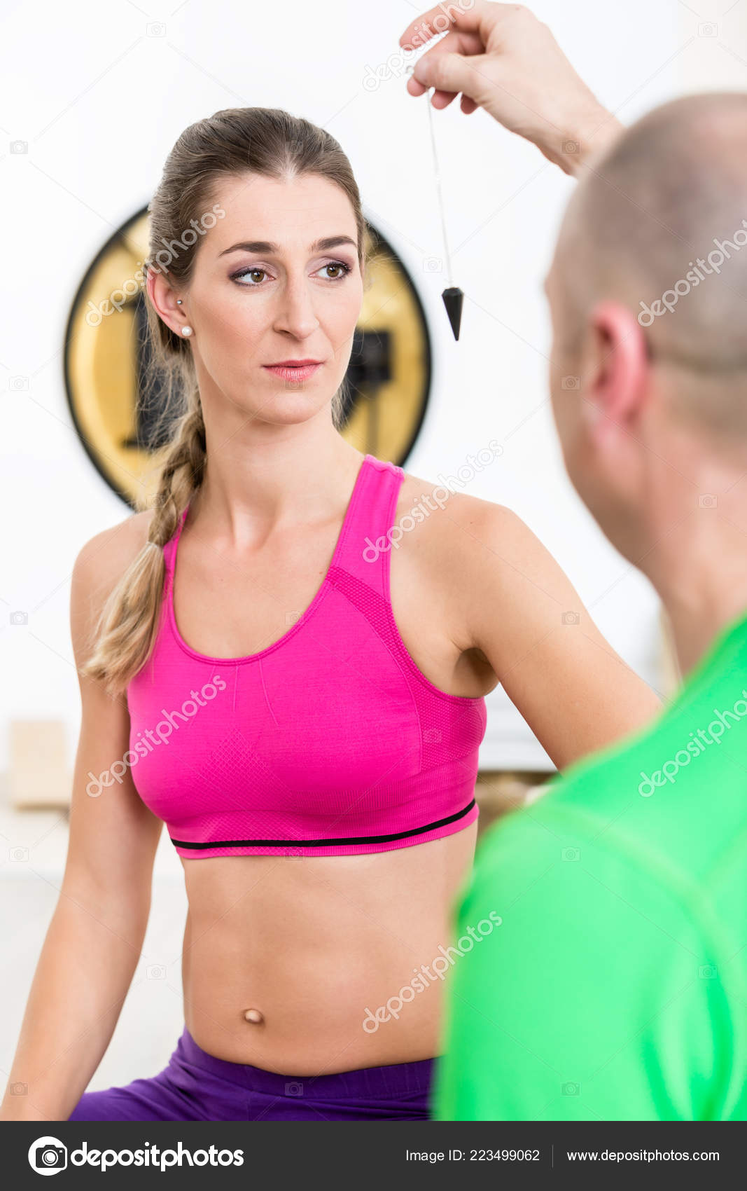 Instructor hypnotizing woman with pendulum tool Stock Photo by