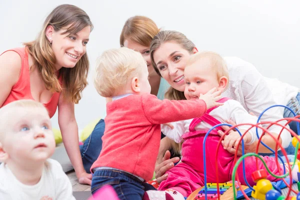 Gruppe glücklicher junger Mütter, die ihre niedlichen und gesunden Babys beobachten — Stockfoto