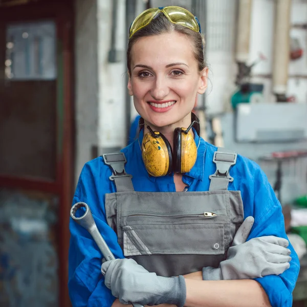 Mujer trabajadora en su taller de metal posando con herramientas — Foto de Stock