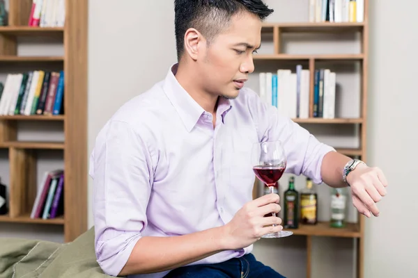 Uomo che tiene il bicchiere di vino guardando il tempo sull'orologio da polso — Foto Stock