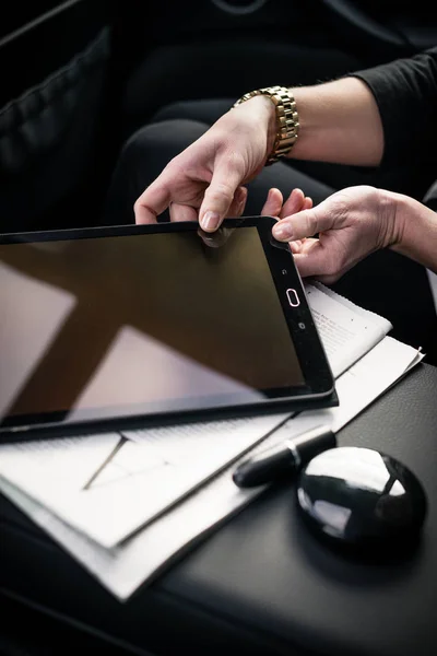 Бизнесвумен, принимающая цифровой планшет в машине — стоковое фото