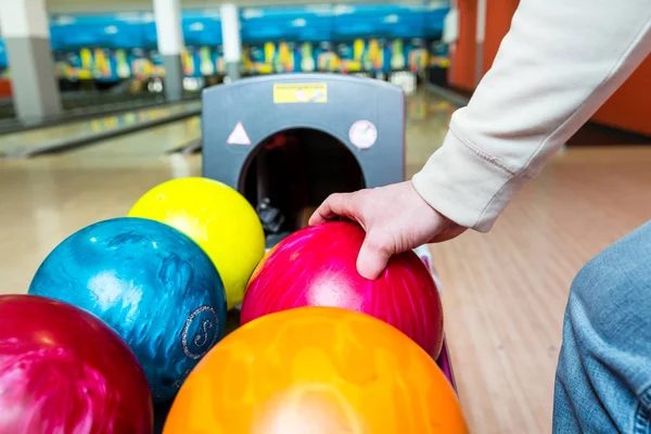 Person som hämtar bowlingklot från rack — Stockfoto