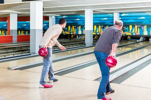 Far och son som spelar bowling spel — Stockfoto