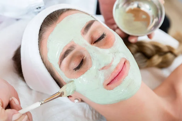 Mujer recibiendo cuidado facial por esteticista en el salón de spa —  Fotos de Stock