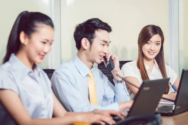 Businesspeople using laptop and telephone — Stock Photo, Image