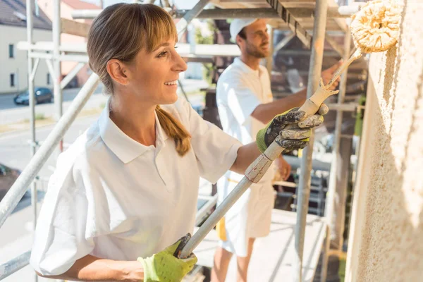 Woman painter painting a wall with yellow paint — Stock Photo, Image