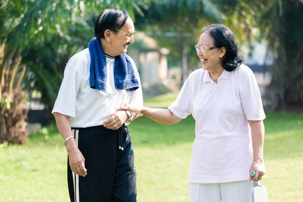 Sorridente coppia anziana in piedi nel parco — Foto Stock