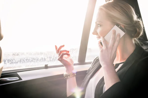 Geschäftsfrau kommuniziert im Auto per Handy — Stockfoto