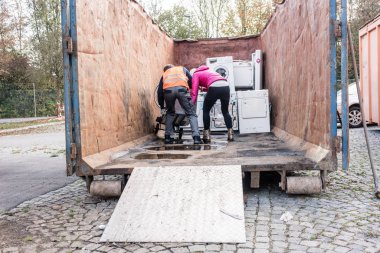 Kadın ve geri dönüşüm merkezi için elektrikli ev aletleri veren adam