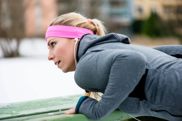 Mujer estirando sus extremidades para hacer ejercicio deportivo en invierno — Foto de Stock