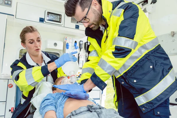 Médico de emergência dando massagem cardíaca para reanimação em ambulância — Fotografia de Stock