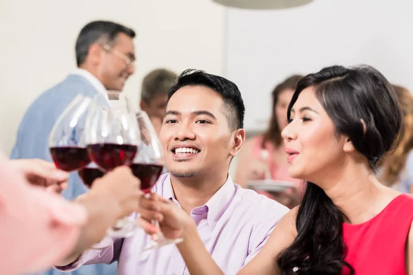 Paar stößt mit Freunden an — Stockfoto