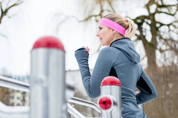Junge Frau trainiert im Winter ihre Beine auf Fitnesspfad — Stockfoto