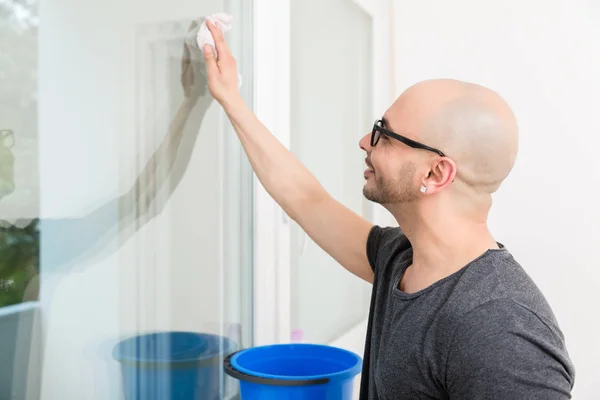 Homem lavando o vidro da janela com pano — Fotografia de Stock