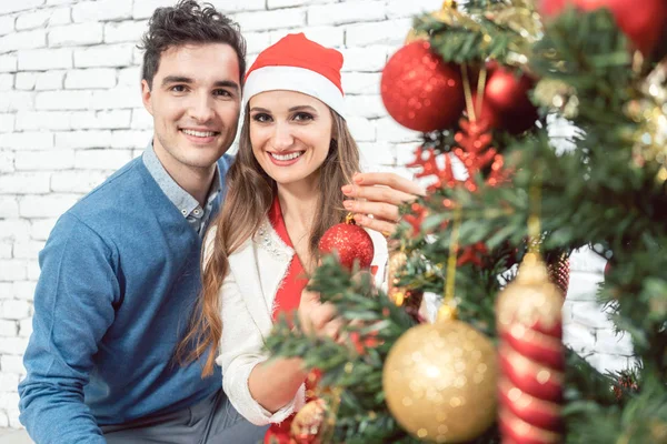 Para w domu dekorowanie drzewo na Boże Narodzenie — Zdjęcie stockowe