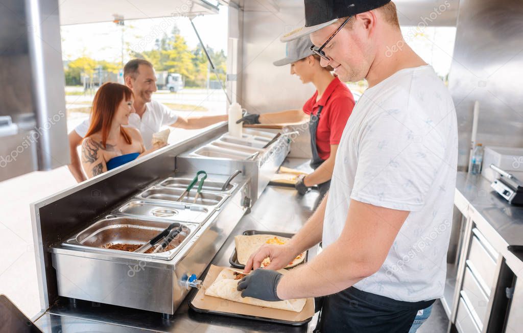 Young chefs in a food truck preparing food