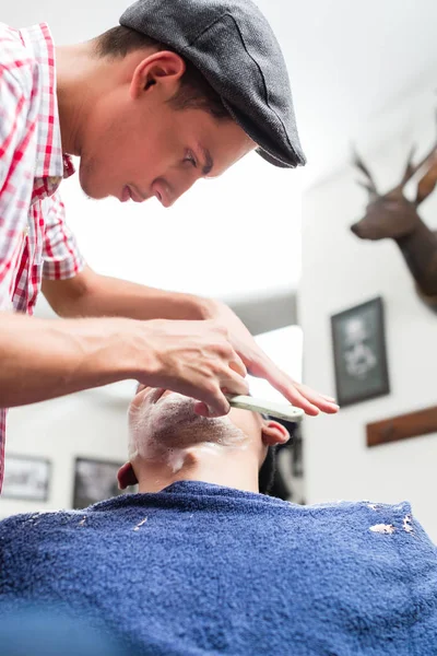 Afeitado peluquero joven con afeitadora recta —  Fotos de Stock