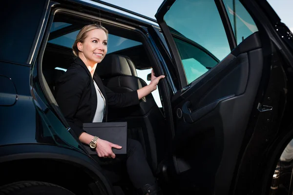 Lächelnde Geschäftsfrau steigt aus Auto — Stockfoto