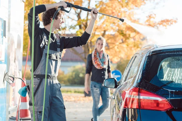 सेवा माणूस महिला कार वॉशमध्ये तिच्या ऑटो स्वच्छ करण्यास मदत करते — स्टॉक फोटो, इमेज