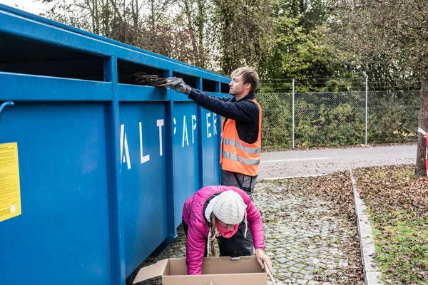 Vrouw en man afvalpapier aanbrengend container op recycling center — Stockfoto