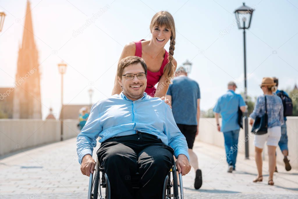 Woman and her friend in a wheelchair having stroll through the town