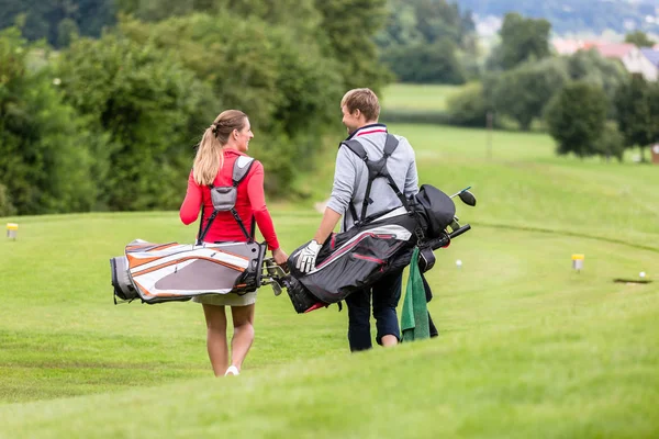 Golfe casal andando e conversando no campo de golfe — Fotografia de Stock