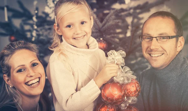 Chica joven ayudando a su familia a decorar el árbol de Navidad —  Fotos de Stock