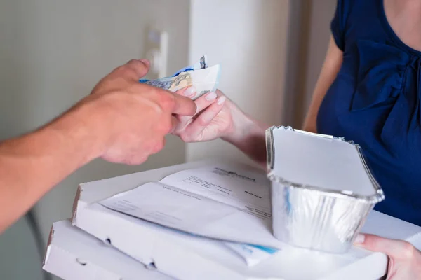 Kunder hand ger pengar för att leverans man — Stockfoto