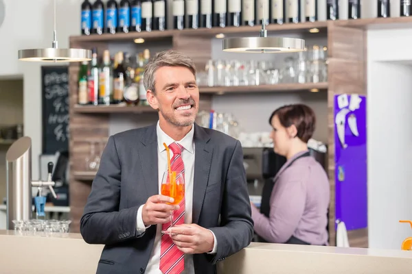 Homem segurando cocktail perto do balcão do bar — Fotografia de Stock