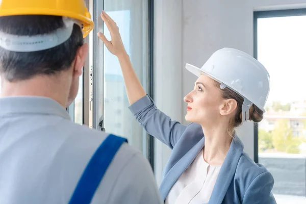 Architect and construction worker checking windows on site — Stock Photo, Image