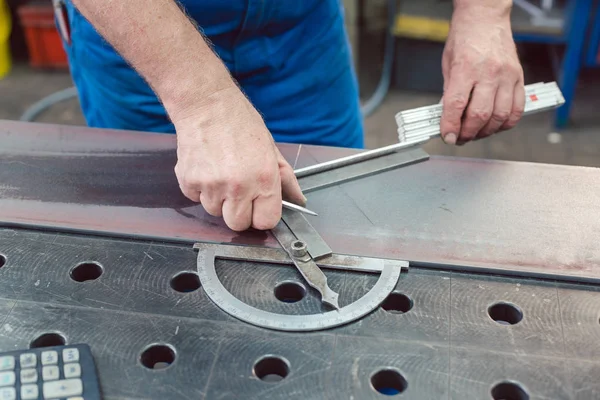 Metalworker usando regla plegable para medir la tira de acero — Foto de Stock