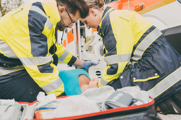 Paramedics performing first aid at ambulance