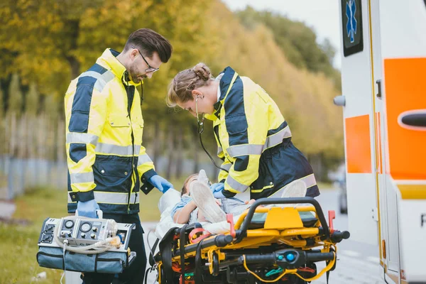 Emergency doctor giving oxygen to accident victim — Stock Photo, Image