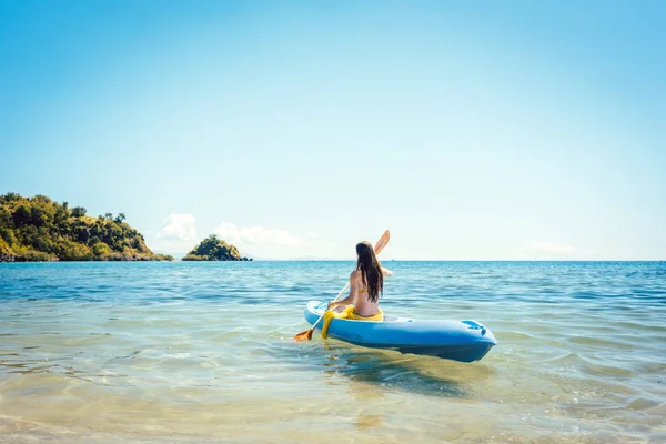 Жінка веслує на каяку на морі в чистій воді — стокове фото