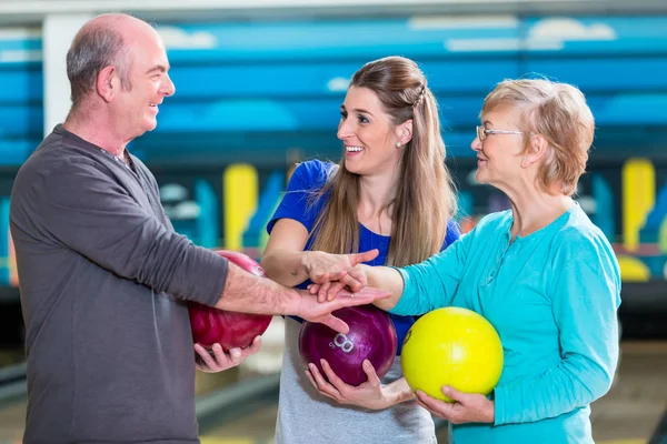 Familia sonriente apilándose las manos — Foto de Stock