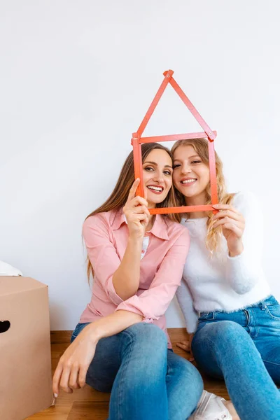 Two women having rented a new apartment moving in