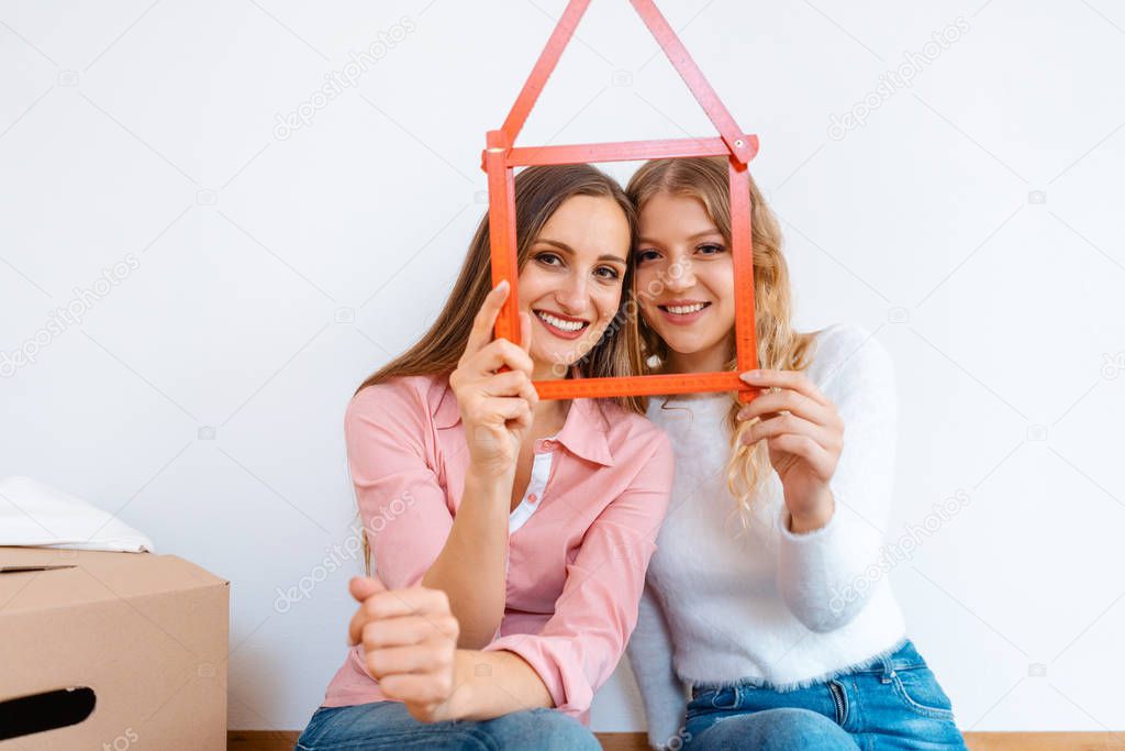 Two women having rented a new apartment moving in 