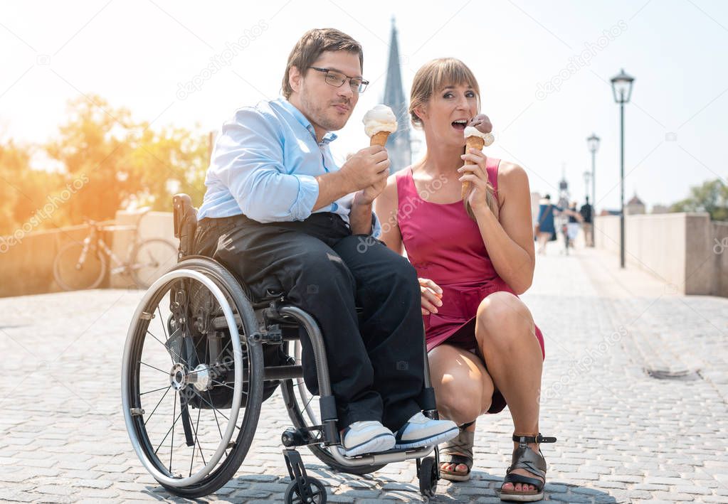 Disabled man and his friend having ice cream in town