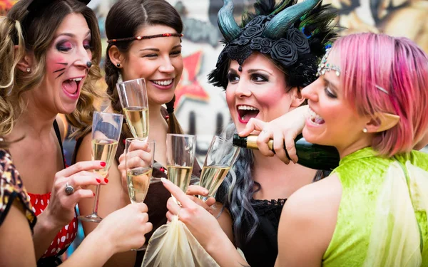 Дівчата в карнавальних парад цокаючись із шампанським — стокове фото