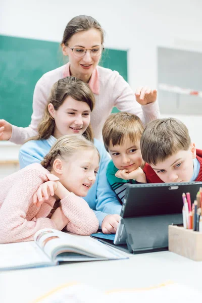 Profesores y estudiantes que utilizan medios y tecnología en el aula — Foto de Stock