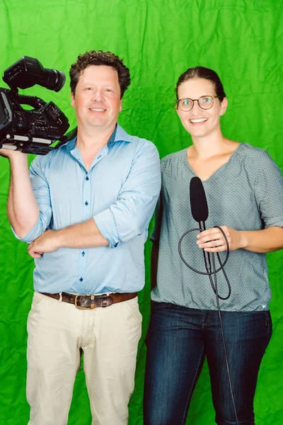 Bemanning van de reporter en cameraman poseren in de studio — Stockfoto