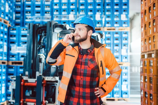 Lavoratore nel magazzino logistico al telefono — Foto Stock